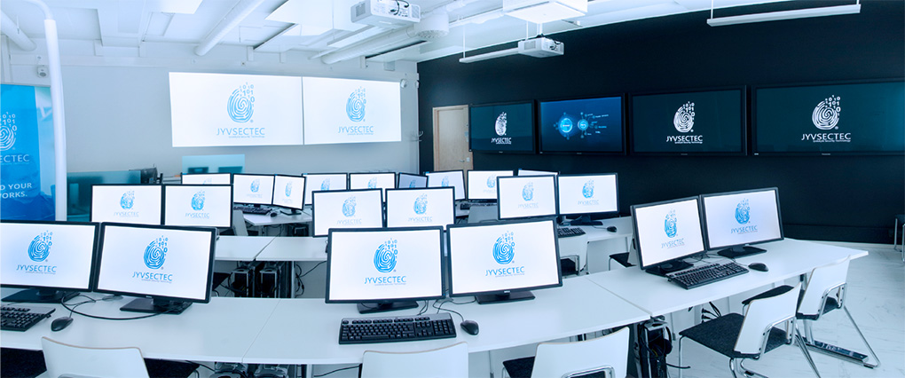 A picture of situation room 1 from the back, showing data projectors, wall-mounted televisions, and computers with multiple displays.